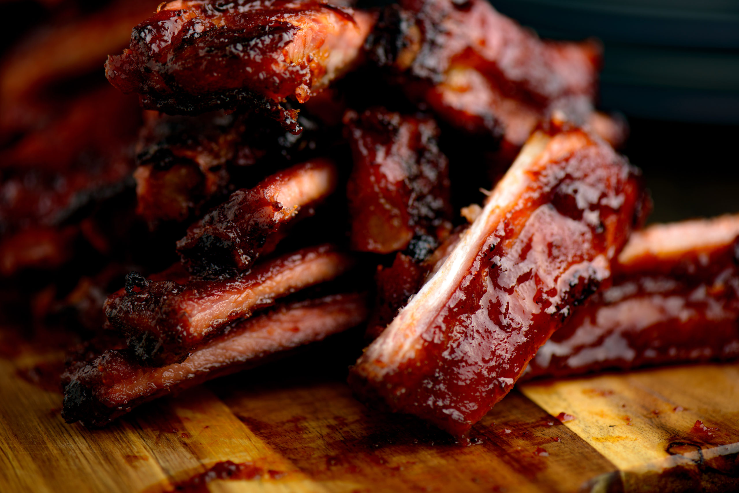 Smoked ribs ready to be eaten on wooden plate
​